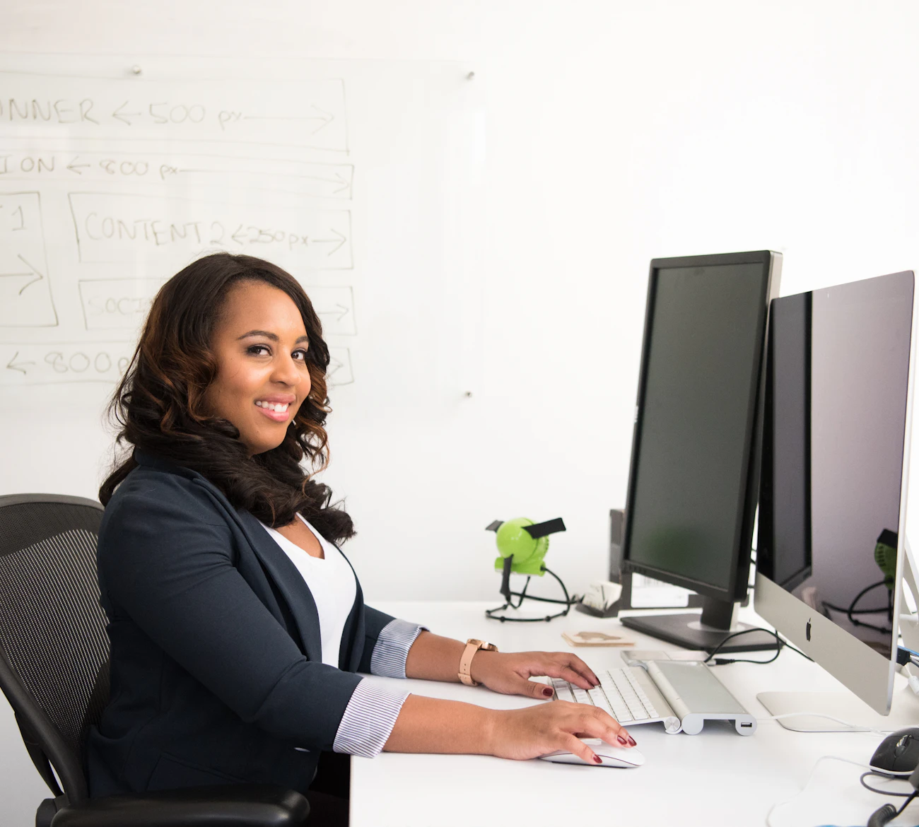 IT professional working at a desk with two monitors