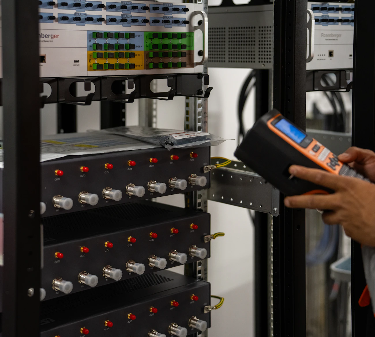Technician testing a server rack with a handheld meter